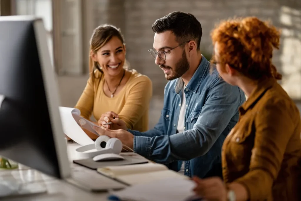 three people looking in front of a computer